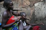 Rugialia Bangura, left, plaits her sister Fatmata's hair in Susan's Bay a slum in Freetown, Sierra Leone, November 9, 2008.