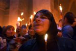 A Christian-Orthodox worshiper holds a candle that has been lit during the Holy Fire ceremony held at the Church of the Holy Sepulchre during the Orthodox Easter Week in Jerusalem, Saturday , April 26, 2003. The Church holds the tomb where many believe Jesus Christ was crucified, buried, and resurrected. The Holy Fire ceremony is meant to assure worshipers that Jesus has not forgotten them and is sending a message of hope through fire. The fire is taken from the inside of the tomb and then rapidly spread throughout the church as the faithful light each others candles.
Photo by: Ann Johansson.