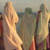 On the south terrace of the Taj Mahal a group of young women in colourful saris gaze over the great bend of the Yamuna River.