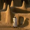 An imam about to lead sunset prayers stands outside the Great Mosque of Djenné,
Mali. Built in 1907 during the French colonial administration, it occupies the site of a
mosque originally constructed in 1240 by the sultan Koi Kunboro. For three centuries
Djenné was a vital religious and trading centre of the kingdoms of Mali and Songhai, the
greatest empires in the history of sub-Saharan Africa.